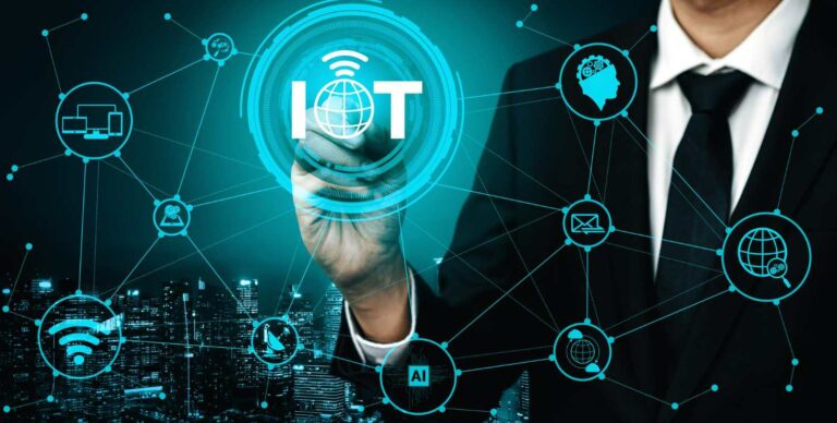 Executive drawing an “IOT” hologram with connected icons (AI, Wi-Fi, cloud, devices) over a city skyline — IoT automation solutions company in Dubai and smart access control system UAE