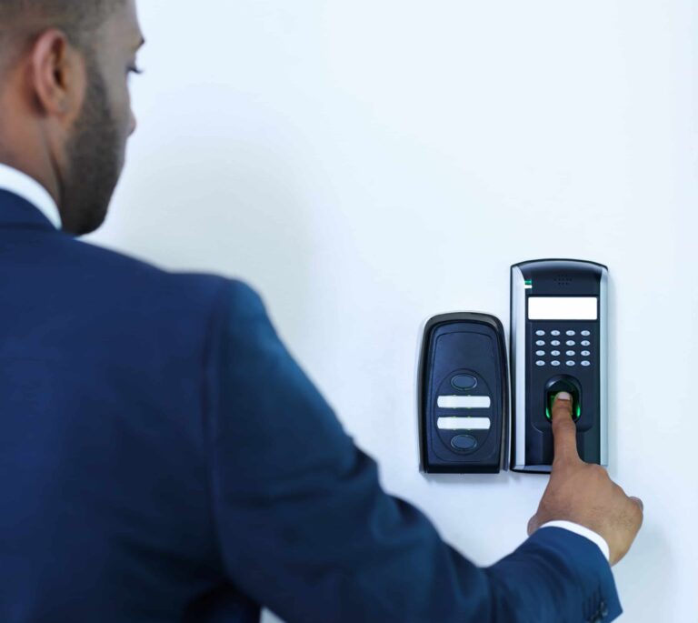 Business user authenticating on a fingerprint keypad with adjacent RFID door reader — biometric access control system Dubai by AiVIZ